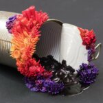 Discarded objects populated with colorful plant, coral, and fungus sculptures by Stephanie Kilgast