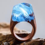 Small ethereal worlds encapsulated in wood and resin rings by Secret Wood